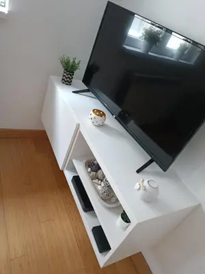 a living room with a large tv on a white table at WHITE apartment in Belgrade