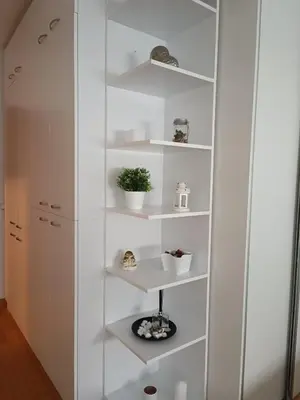 a white cabinet with white shelves in a room at WHITE apartment in Belgrade