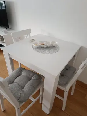 a white table and two chairs with bowls on it at WHITE apartment in Belgrade
