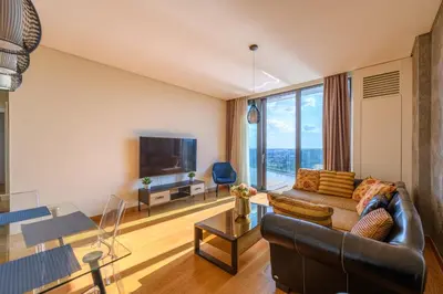 a living room with a couch and a large window at BW Residences penthouse 2BDR with pool&gym in Belgrade
