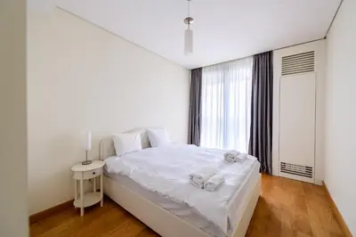 a white bedroom with a bed and a window at BW Residences penthouse 2BDR with pool&gym in Belgrade