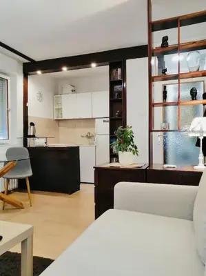 a living room with a white couch and a kitchen at Dorcol hideaway in Belgrade