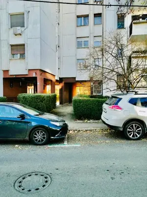 two cars parked in a parking lot in front of a building at Dorcol hideaway in Belgrade