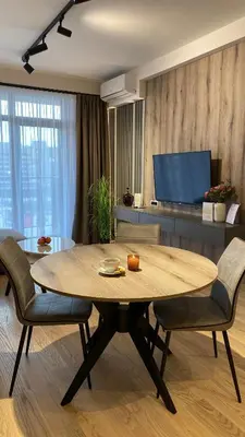 a living room with a table and a tv at DOM Boutique Apartments AURORA in Belgrade
