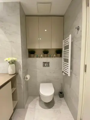 a bathroom with a white toilet in a room at DOM Boutique Apartments AURORA in Belgrade