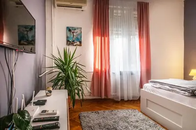a bedroom with a bed and a table with a plant at Neimar Apartment with Great Wi-Fi and free parking in Belgrade