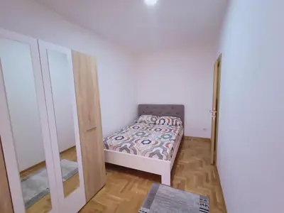 a small bedroom with a bed and a mirror at Apartman Ledine in Ledine