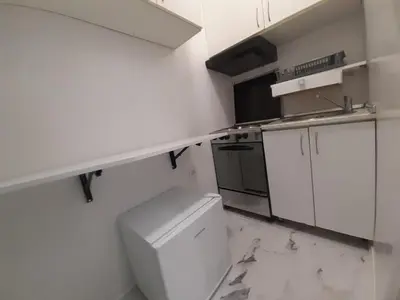 a white kitchen with a sink and a refrigerator at Viktorija 1 in Čukarica