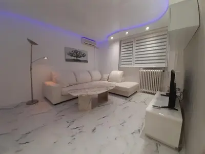 a living room with a white couch and a table at Viktorija 1 in Čukarica