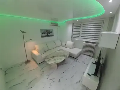 a living room with a white couch and a table at Viktorija 1 in Čukarica