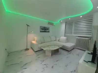 a living room with a white couch and a table at Viktorija 1 in Čukarica