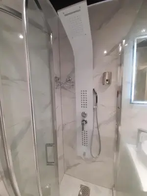 a shower with a glass door in a bathroom at Viktorija 1 in Čukarica