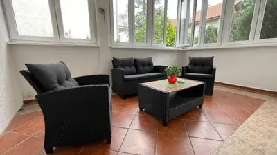 a living room with chairs and a table and windows at Filip Luxury Suite in Belgrade