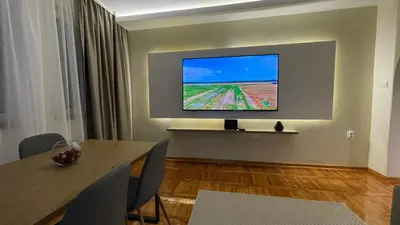a room with a table and a television on a wall at Filip Luxury Suite in Belgrade