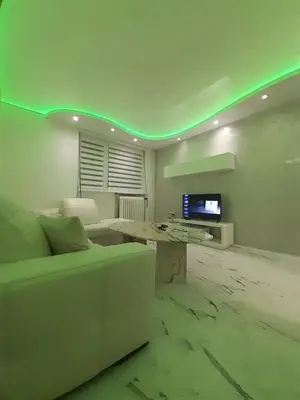 a living room with a white couch and a tv at Brdo lux in Belgrade