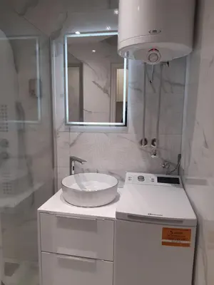 a white bathroom with a sink and a mirror at Brdo lux in Belgrade