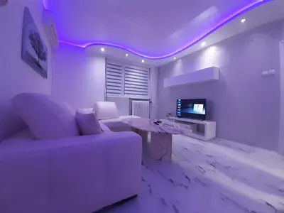 a living room with a white couch and a tv at Brdo lux in Belgrade