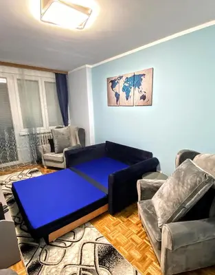 a living room with a blue couch and chairs at Peti in Belgrade