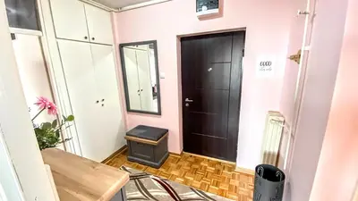 a hallway with a black door and a table at Peti in Belgrade