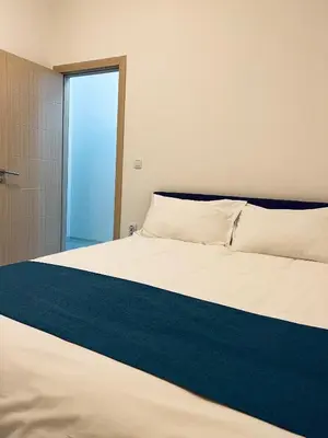 a bedroom with a bed with a blue blanket at \u99a8\u4e4b\u5bb6-\u534e\u4eba\u516c\u5bd3\u6c11\u5bbf \u4e09\u5ba4\u4e00\u5385 in Ledine