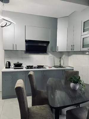 a kitchen with a table and chairs and a stove at \u99a8\u4e4b\u5bb6-\u534e\u4eba\u516c\u5bd3\u6c11\u5bbf \u4e09\u5ba4\u4e00\u5385 in Ledine