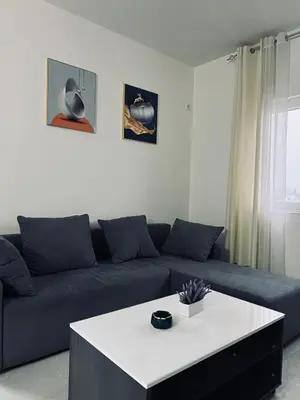 a living room with a blue couch and a white table at \u99a8\u4e4b\u5bb6-\u534e\u4eba\u516c\u5bd3\u6c11\u5bbf \u4e09\u5ba4\u4e00\u5385 in Ledine