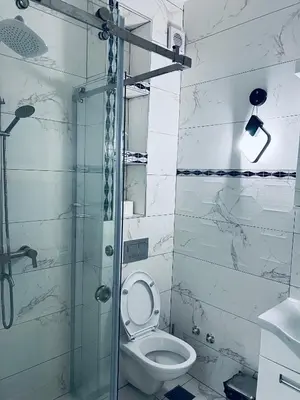 a bathroom with a toilet and a glass shower at \u99a8\u4e4b\u5bb6-\u534e\u4eba\u516c\u5bd3\u6c11\u5bbf \u4e09\u5ba4\u4e00\u5385 in Ledine