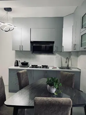 a kitchen with a table and chairs and a kitchen with white cabinets at \u99a8\u4e4b\u5bb6-\u534e\u4eba\u516c\u5bd3\u6c11\u5bbf \u4e8c\u5ba4\u4e00\u5385 in Ledine