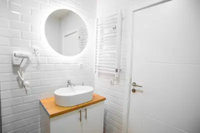 a white bathroom with a sink and a mirror at Premium Suites Terazije in Belgrade