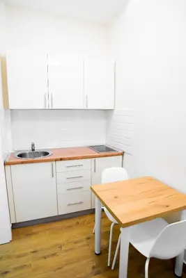 a kitchen with a wooden table and white cabinets at Premium Suites Terazije in Belgrade