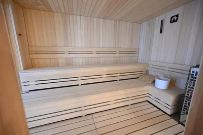 a sauna with two benches and a bucket in it at Hotel Tamiš & Spa in Pančevo