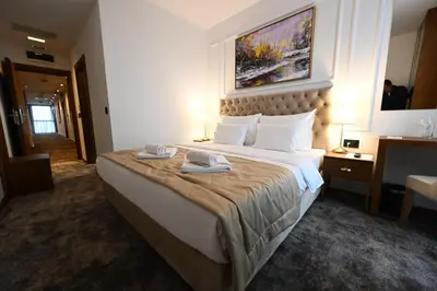 a hotel room with a large bed with towels on it at Hotel Tamiš & Spa in Pančevo