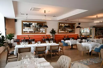 a dining room with white tables and chairs at Hotel Tamiš & Spa in Pančevo