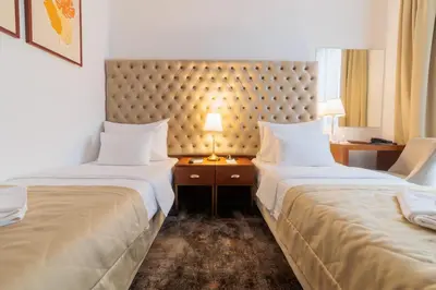 two beds in a hotel room with a headboard at Hotel Tamiš & Spa in Pančevo