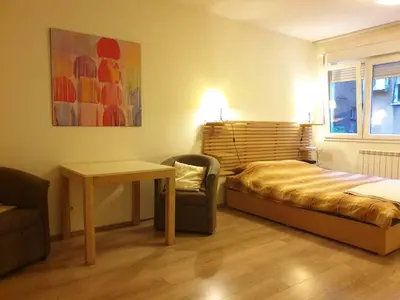 a bedroom with a bed and a table and a chair at STUDIO 77 in Belgrade