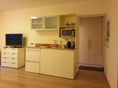 a kitchen with white cabinets and a counter with a television at STUDIO 77 in Belgrade