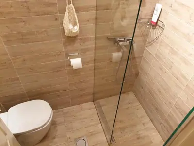 a bathroom with a toilet and a glass shower at STUDIO 77 in Belgrade
