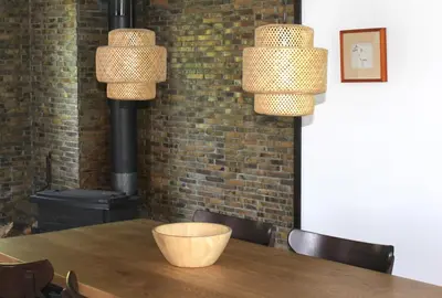 a table with two lights and a wood stove at Buzzing Retreat in Velika Remeta