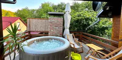 a hot tub on a patio with an umbrella at Buzzing Retreat in Velika Remeta