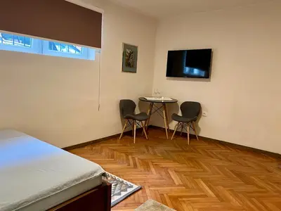 a bedroom with a table and two chairs and a tv at Dorcoleta Apartment in Belgrade