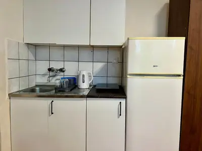 a kitchen with white cabinets and a white refrigerator at Dorcoleta Apartment in Belgrade