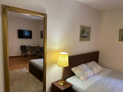 a bedroom with a mirror and a bed and a table at Dorcoleta Apartment in Belgrade