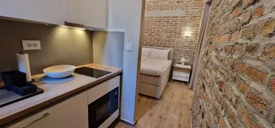 a kitchen with a sink and a brick wall at Old Town Apartments Rajiceva 3 in Belgrade