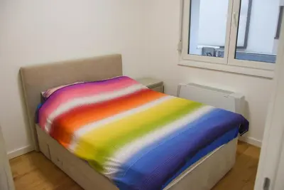 a bed with a colorful blanket on it in a room at Apartment Barcelona Zemun Belgrade in Zemun