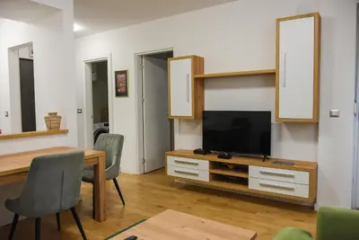a living room with a television and a table and chairs at Apartment Barcelona Zemun Belgrade in Zemun