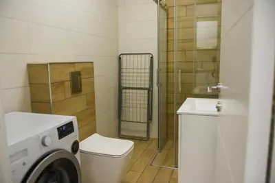 a bathroom with a washing machine and a toilet at Apartment Barcelona Zemun Belgrade in Zemun