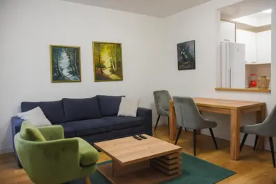 a living room with a couch and a table and chairs at Apartment Barcelona Zemun Belgrade in Zemun