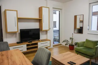 a living room with a television and a table and chairs at Apartment Barcelona Zemun Belgrade in Zemun