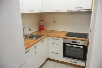 a small kitchen with white cabinets and a sink at Apartment Barcelona Zemun Belgrade in Zemun