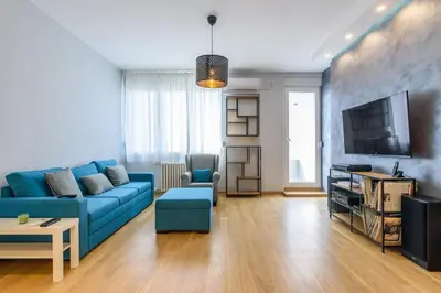 a living room with a blue couch and a tv at Brand new flat near Tesla museum in Belgrade